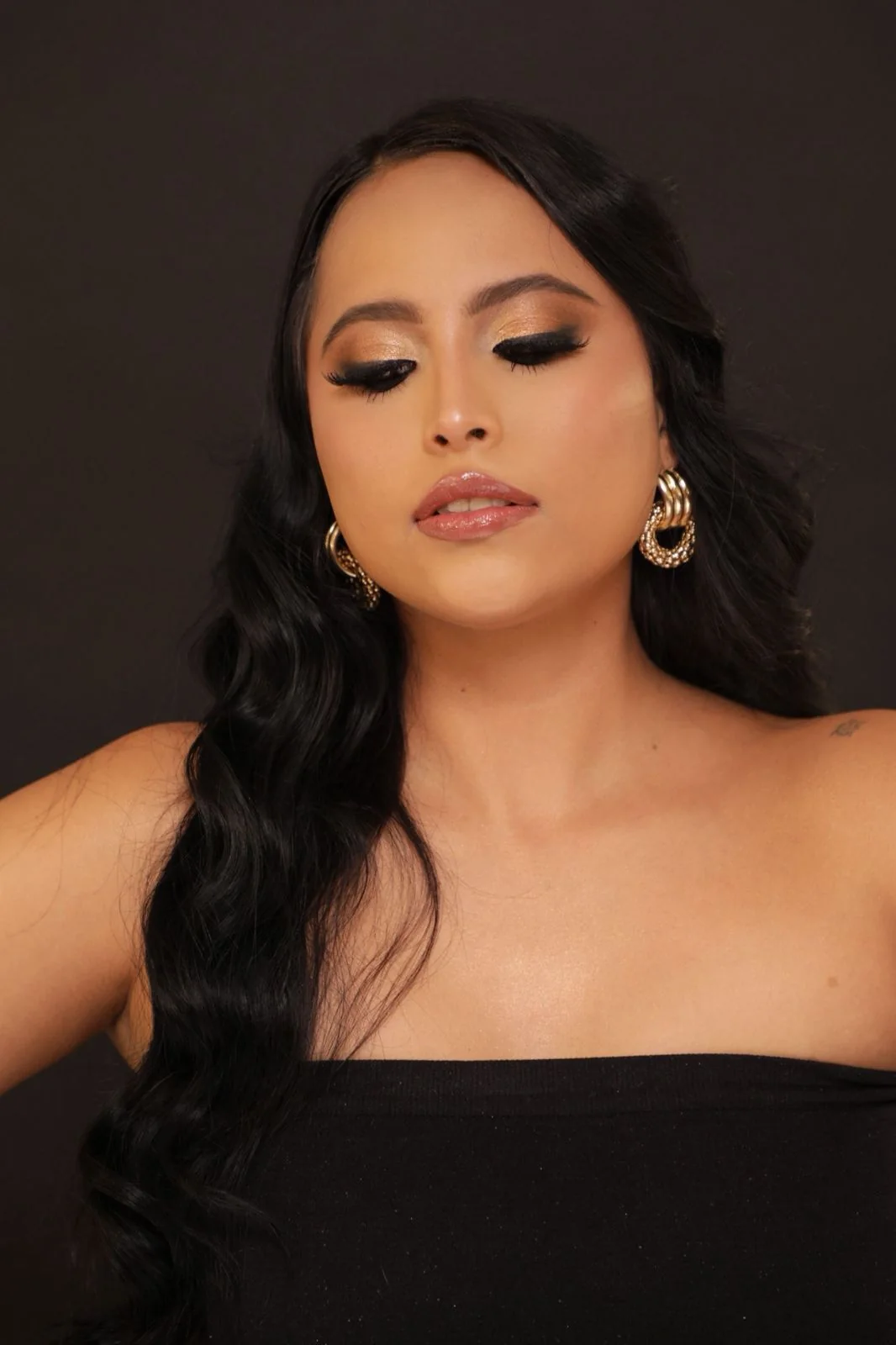Retrato con maquillaje dorado y ondas suaves en el cabello, por Glow Beauty
